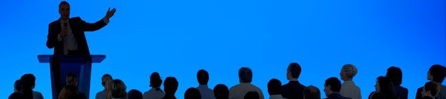 corporate-businessman-giving-presentation-large-audience2